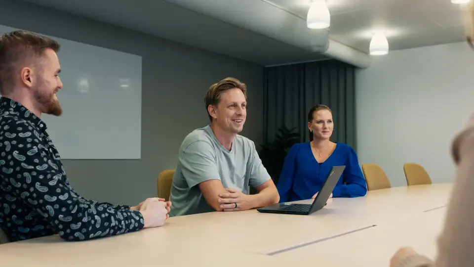 Tre personer vid konferensbord, Freddie Börjesson i mitten