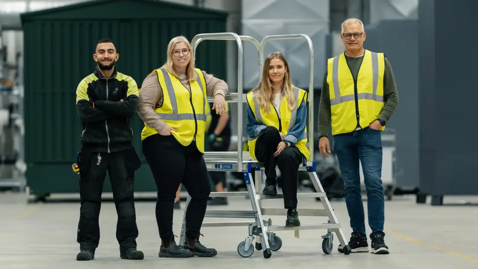 Holtabs fyra medarbetare framför nätstationer i fabriken i Sverige